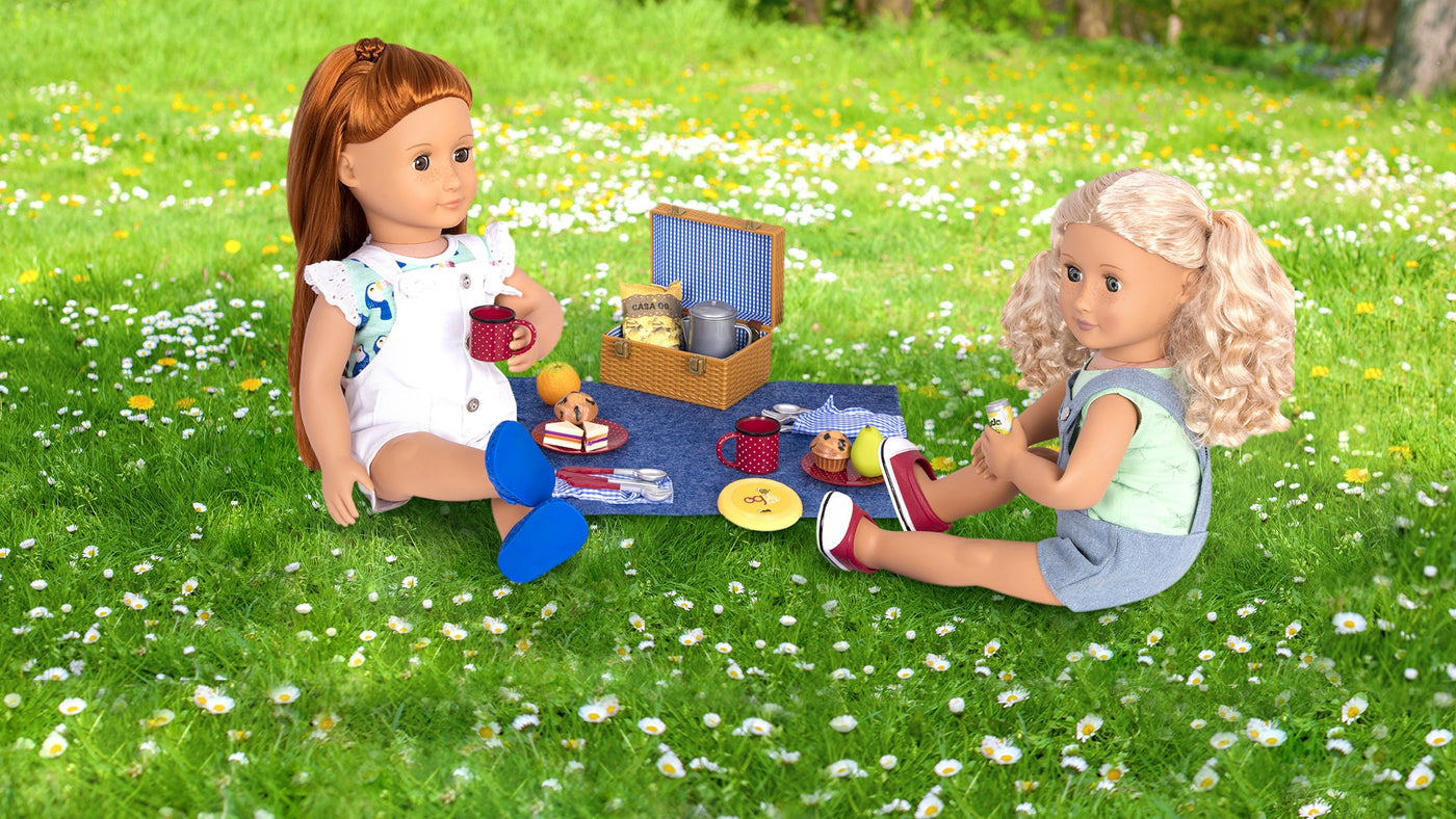 Dos muñecas disfrutando de un picnic en el parque con una cesta de picnic y comida